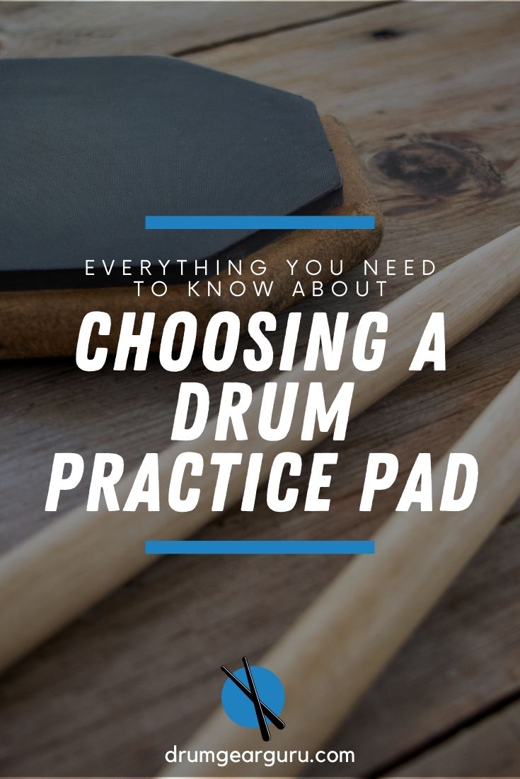 A drum practice pad on a wooden table, with two drumsticks in the foreground